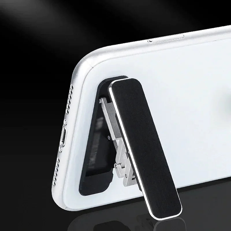 Ultra-slim aluminum folding phone stand attached to a smartphone, showcasing its adjustable and portable design.