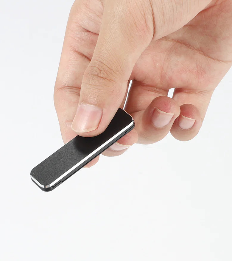 Hand holding a small, sleek black aluminum phone stand, showcasing its portable and compact design.